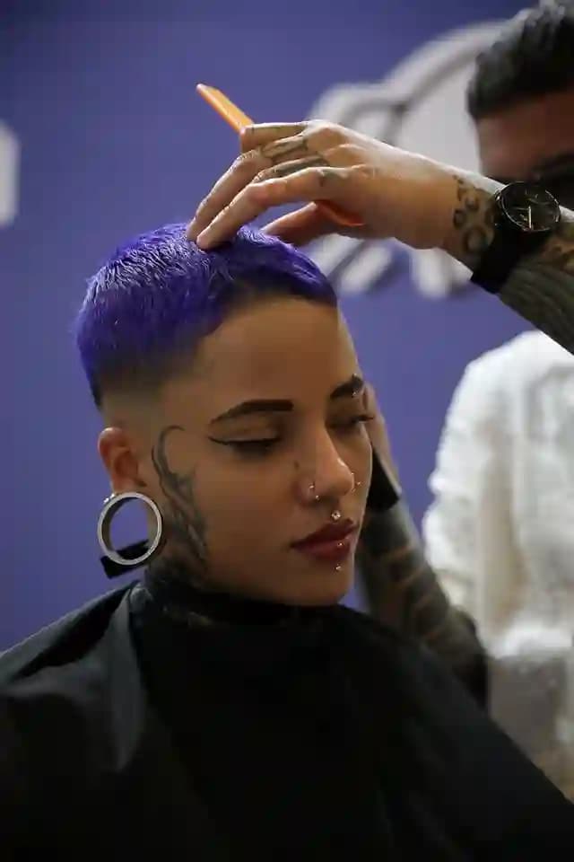 Estilista realizando un corte a una clienta con cabello de color en la feria Belleza y Salud de Bogotá, Colombia