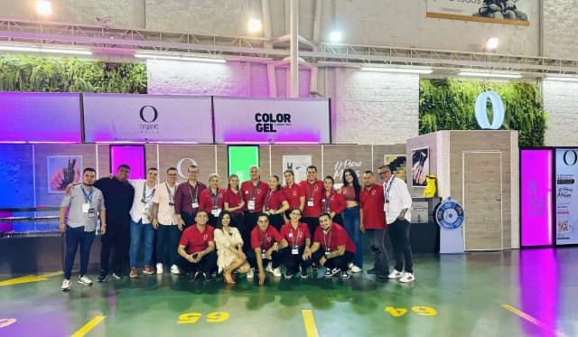 Expositores y profesionales en feria de belleza junto al stand de Weibook