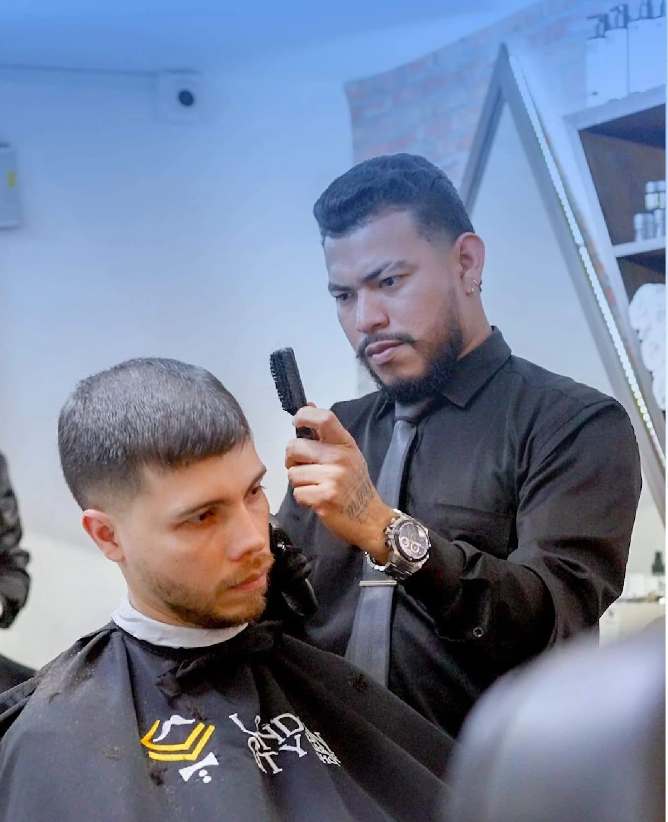 Barbero profesional preparado para cortar el cabello en barbería gestionada con Weibook