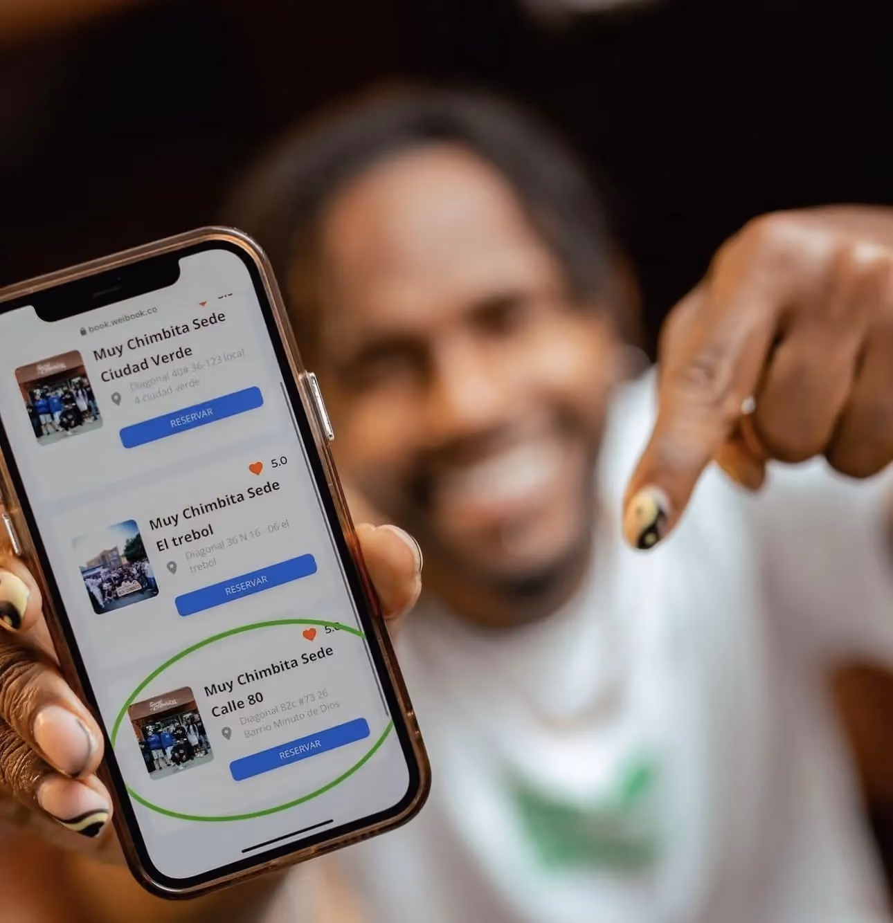 Cliente reservando cita en una barbería con la app de WeiBook en la feria de belleza de Bogotá, Colombia