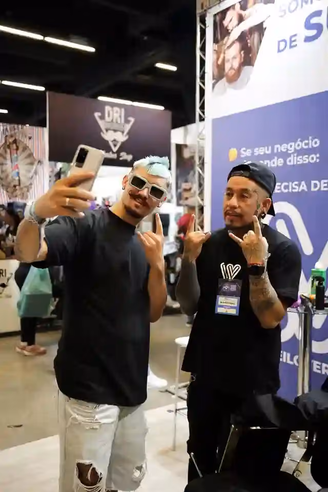 Barberos tomándose una selfie en el stand de WeiBook en la Barber Week de São Paulo, Brasil