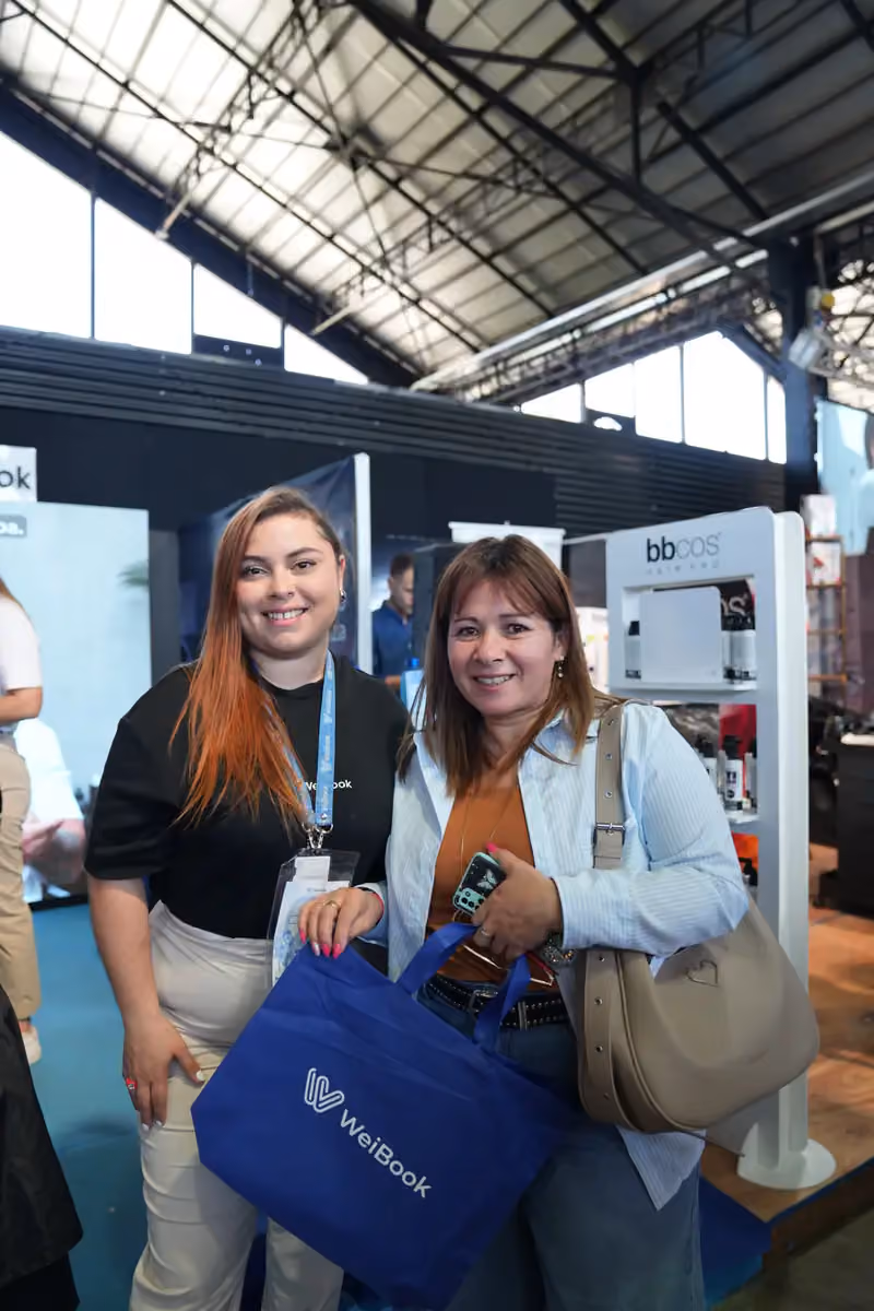 Asesora y clienta posan con una bolsa de WeiBook en Argentina