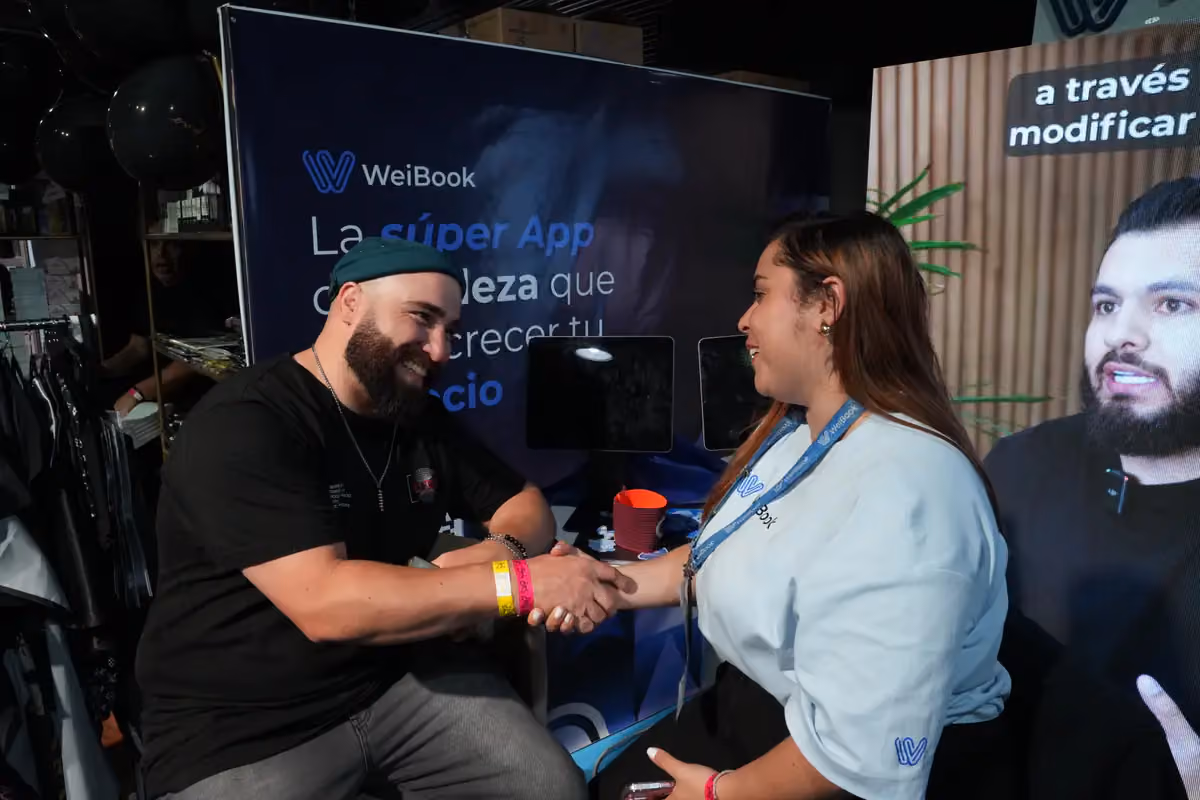 Cliente saluda a una asesora de WeiBook en una feria de Argentina