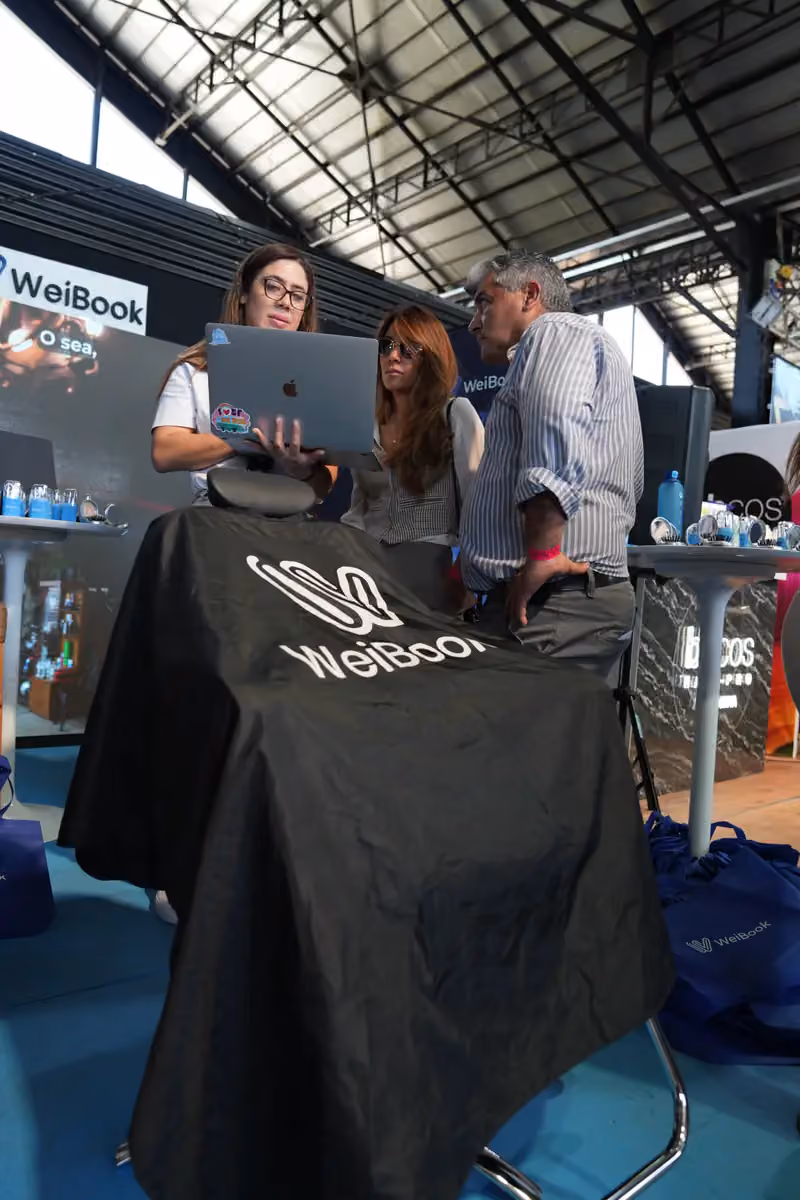Asesora de WeiBook muestra la plataforma a visitantes en Argentina
