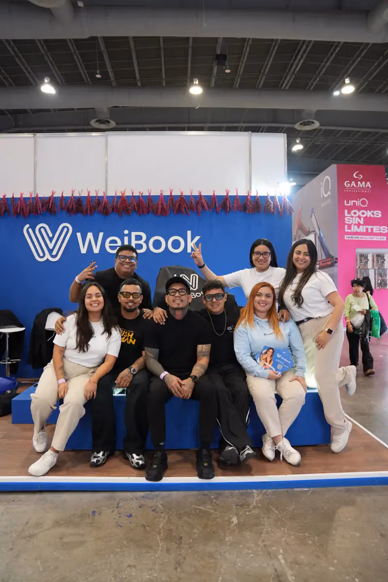 Equipo y clientes posan en el stand de WeiBook en México