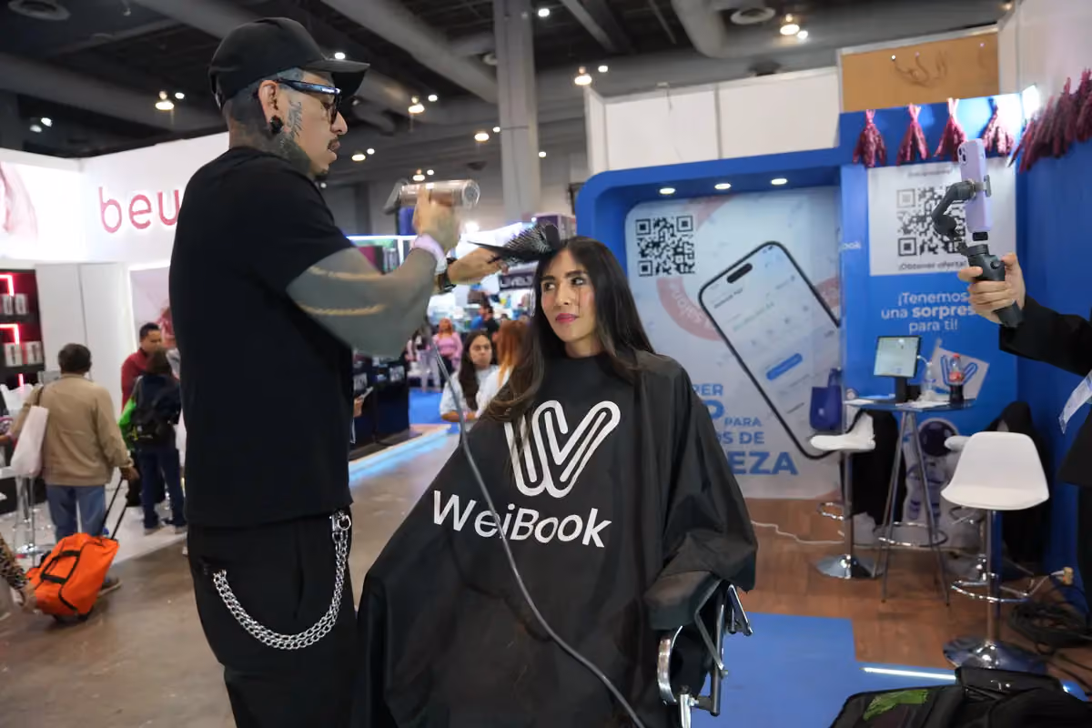Estilista peina en vivo a una modelo en el stand de WeiBook en México