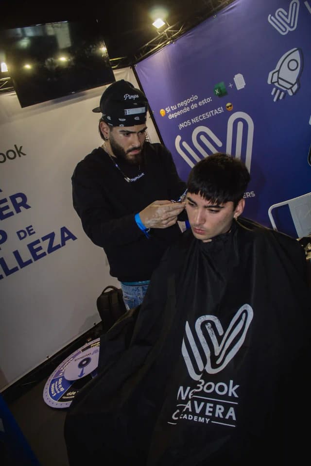 Barbero realizando corte profesional en evento con apoyo de Weibook