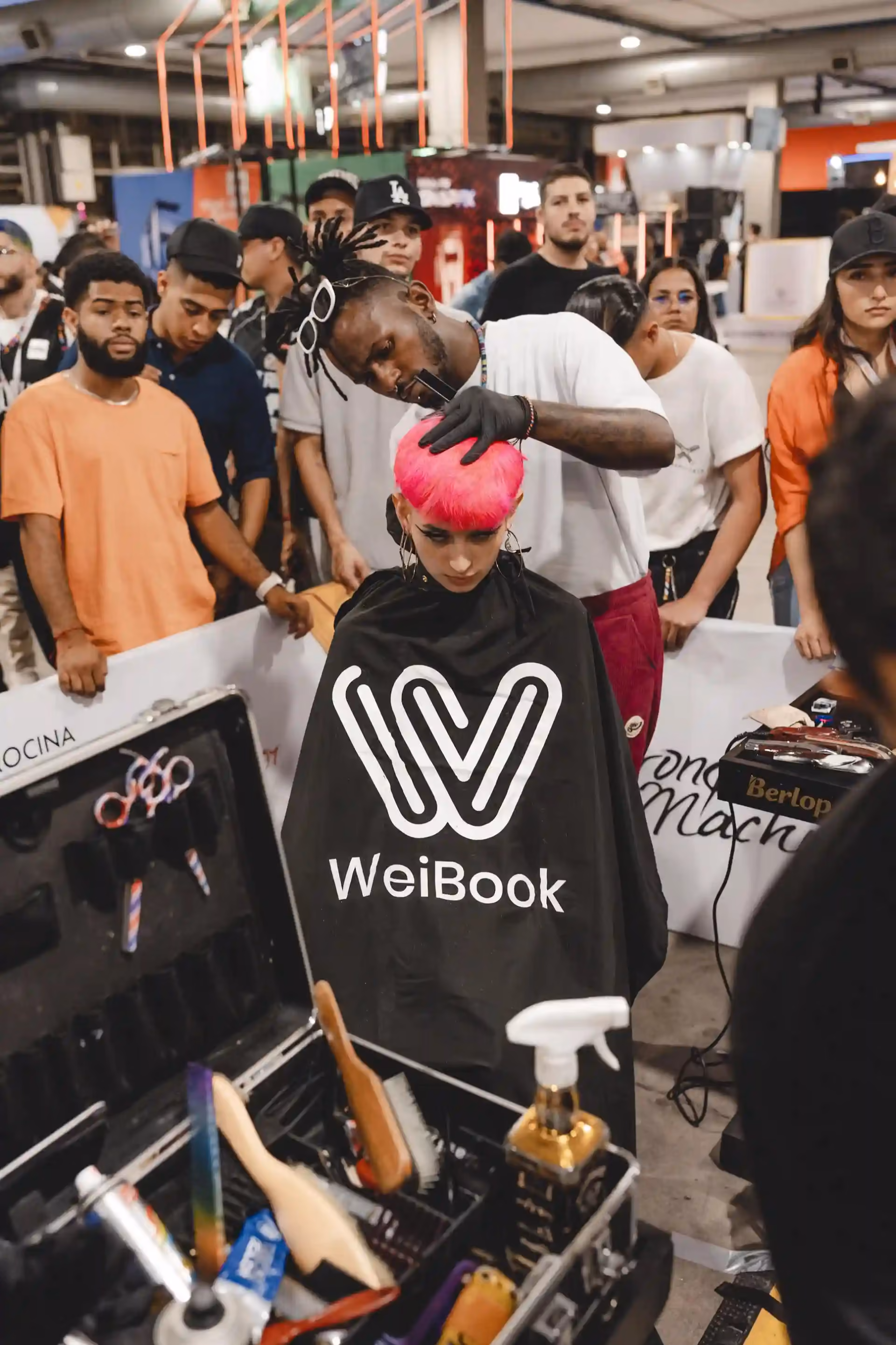 Barbero compitiendo en un concurso de corte en vivo en la feria de barberías de Medellín, Colombia