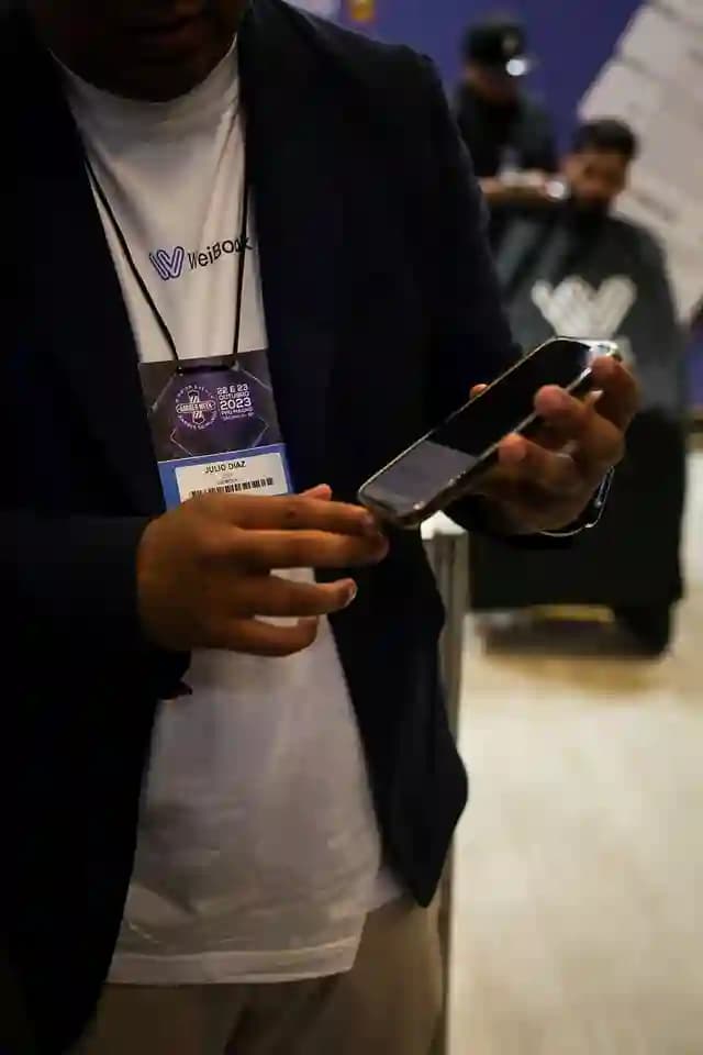 Profesional mostrando la app de reservas de Weibook en su móvil durante evento