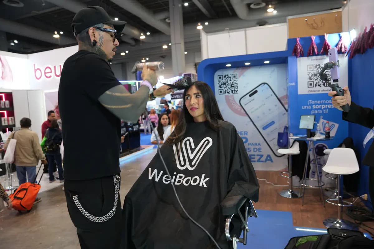 Estilista peina en vivo a una modelo en el stand de WeiBook en México